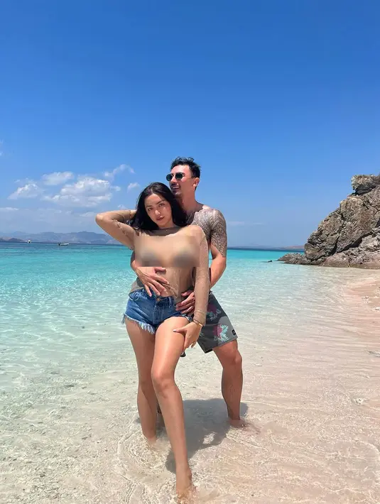 Perempuan kelahiran Jakarta 35 tahun silam itu bergaya hot bersama suami tercinta di pinggir pantai dengan pasir warna pink. [Instagram/inijedar]