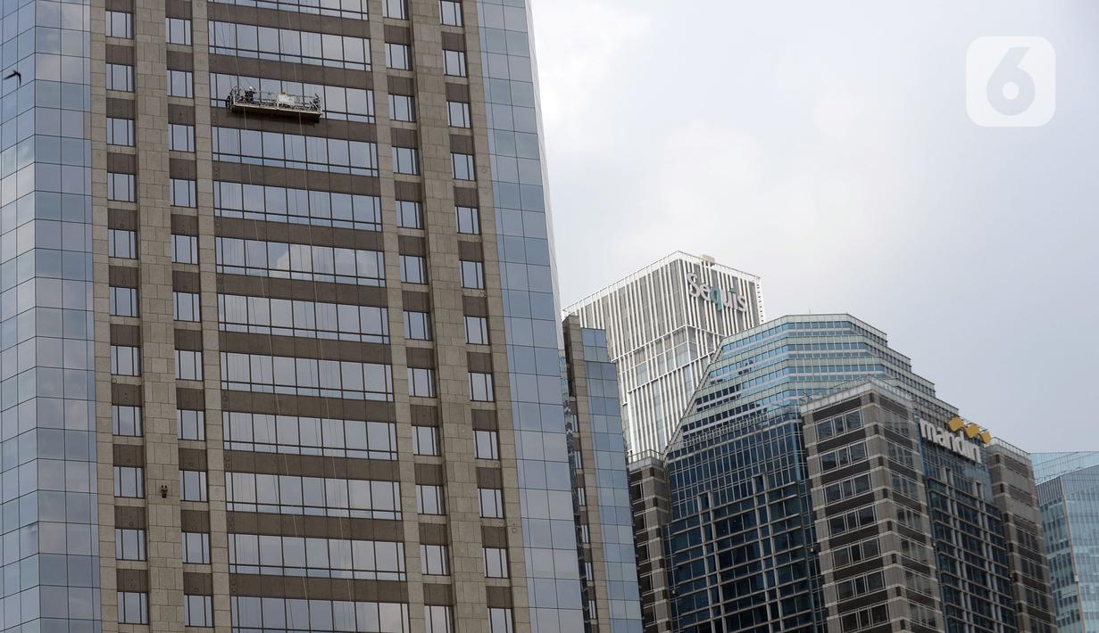 Pekerja membersihkan kaca gedung bertingkat di kawasan Sudirman Central Business District (SCBD), Jakarta, Senin (8/6/2020). Hampir tiga bulan kebijakan work from home (WFH) akibat pandemi COVID-19, banyak gedung bertingkat tidak terawat hari ini mulai dibersihkan. (merdeka.com/Dwi Narwoko)