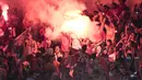 Suporter Persija Jakarta, The Jakmania, menyalakan flare usai mengalahkan Mitra Kukar pada laga Liga 1 di SUGBK, Jakarta, Minggu (9/12). Persija menang 2-1 atas Mitra. (Bola.com/Yoppy Renato)