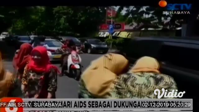 Puluhan dokter rumah sakit dan para medis di Kabupaten Sidoarjo membubuhkan cap lima jari dan bagikan bunga kepada pengendara yang melintas di Jalan Raden Fatah Sidoarjo. Aksi mereka untuk memperingati hari AIDS sedunia, 1 Desember.
