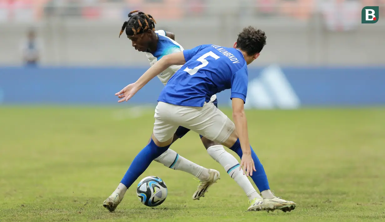Pemain Timnas Inggris U-17, Joel Ndala, berusaha melewati pemain Uzbekistan U-17, Rustam Ashurmatov, pada babak 16 besar Piala Dunia U-17 2023 di Jakarta International Stadium (JIS), Rabu (22/11/2023). The Three Lions muda kalah 1-2 dari Uzbekistan. (Bola.com/M Iqbal Ichsan)