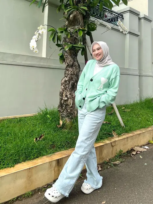 Gaya kasual Melody Laksani Eks JKT48 dengan cardigan warna hijau pastel, celana jeans, dan hijab krem cocok untuk hangout. [Instagram/melodylaksani92]