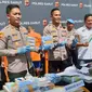 Kapolres Garut AKBP Rio Wahyu Anggoro bersama Wakapolres dan Kasatnarkoba Polres Garut menujukan barang bukti puluhan ribu butir obat keras terbatas dan ratusan botol jamu ilegal. (Liputan6.com/Jayadi Supriadin),