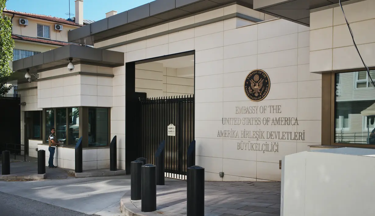 Petugas keamanan berdiri di luar pintu masuk ke Kedutaan Besar Amerika Serikat di Ankara, Turki, (20/8). Kedubes AS di Turki ditembaki pria bersenjata tak dikenal dini hari tadi, sekitar pukul 05.00 waktu setempat. (AP Photo/Burhan Ozbilici)