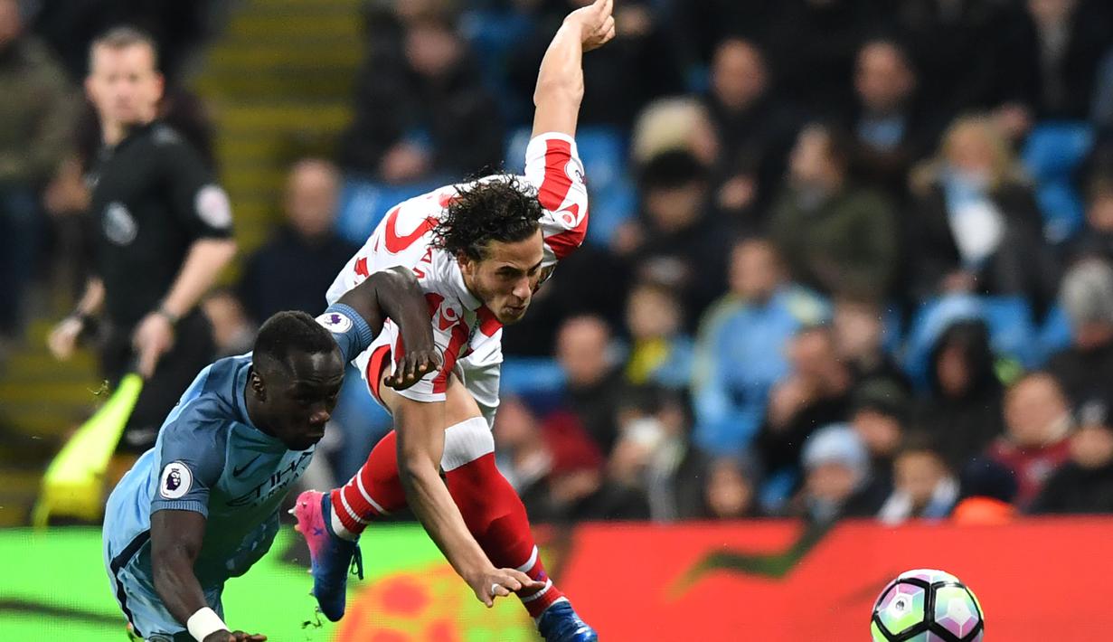 Pemain Manchester City,  Bacary Sagna (kiri) berebut bola dengan pemain Stoke City, Ramadan Sobhi pada lanjutan Premier League di Etihad Stadium, (8/3/2017). Manchester City bermain imbang 0-0.  (AFP/Anthony Devlin)