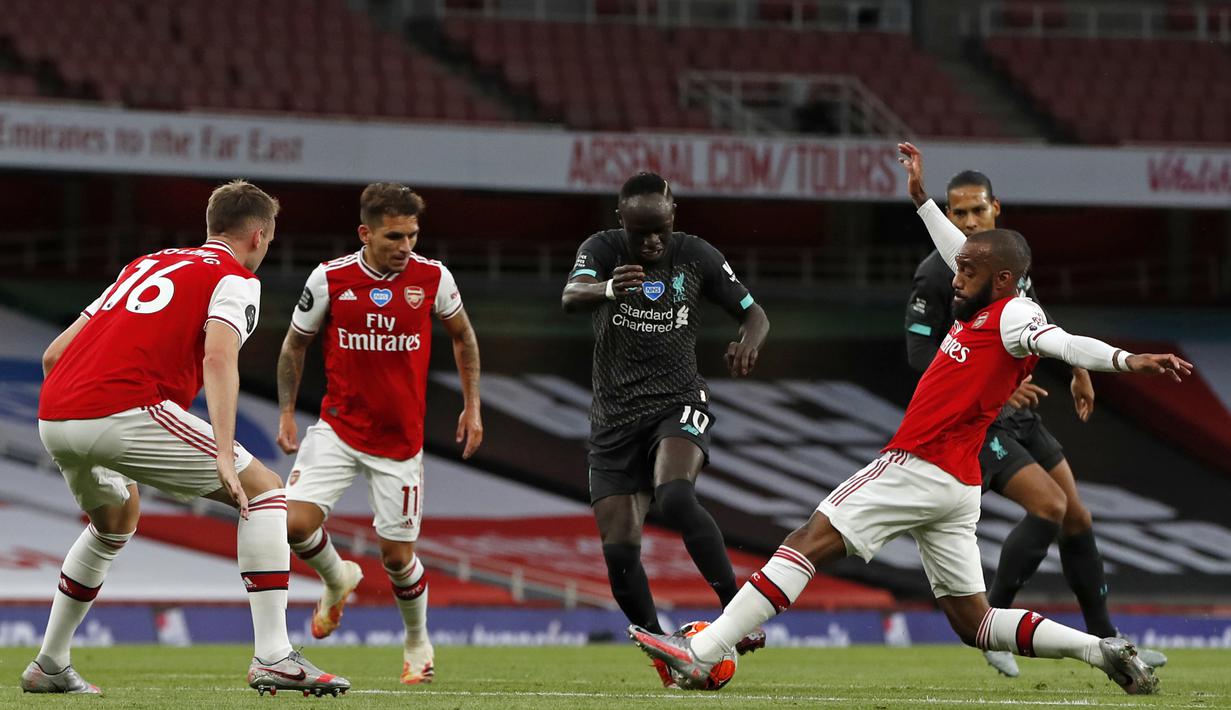 Striker Liverpool, Sadio Mane, berebut bola dengan bek Arsenal, Rob Holding, pada laga lanjutan Premier League pekan ke-36 di Emirates Stadium, Kamis (16/7/2020) dini hari WIB. Arsenal menang 2-1 atas Liverpool. (AFP/Paul Childs/pool)