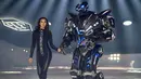 Model Irina Shayk melenggang ditemani robot sambil membawakan koleksi desainer Philipp Plein dalam New York Fashion Week 2018, Sabtu (10/2). Robot warna hitam yang bentuknya menyerupai Transformers itu lalu berjalan di sepanjang catwalk  (AP/Craig Ruttle)