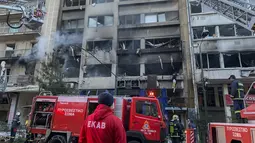 Petugas pemadam kebakaran menggunakan tangga udara untuk mencari orang yang terperangkap di dalam bangunan yang rusak menyusul ledakan di pusat kota Athena, Rabu (26/1/2022).  Ledakan juga menghancurkan etalase toko terdekat di bagian sibuk kota. Athena tengah. (AP Photo/Derek Gatopoulos)