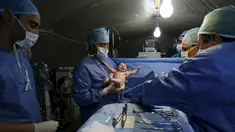 Dokter asal Maroko, menggendong bayi Siwar yang lahir melalui cesar di rumah sakit kamp pengungsian Al Zaatari, Yordania, 7 Maret 2016. Siwar adalah anak ketiga dari keluarga Daraa asal Suriah yang lahir di kamp pengungsian. (REUTERS/Muhammad Hamed)