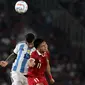 Pemain Timnas Indonesia Dendy Sulistyawan (kanan) berebut bola atas dengan pemain Argentina Cristian Gabriel Romero saat laga FIFA Matchday di Stadion Utama Gelora Bung Karno (SUGBK), Jakarta, Senin (19/6/2023). (Liputan6.com/Helmi Fithriansyah)