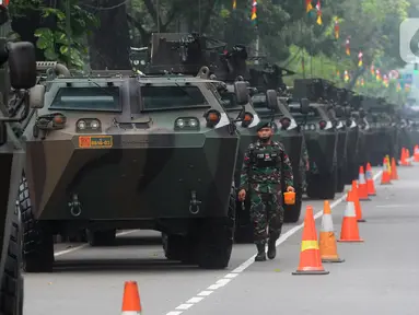 Tentara berjalan di samping kendaraan taktis TNI yang dipamerkan di depan Istana Merdeka, Jakarta, Senin (4/10/2021). Ratusan alat utama sistem persenjataan (Alutsista) TNI dipamerkan sepanjang pinggir jalan sekeliling kawasan Monas dalam rangka peringatan HUT ke-76 TNI. ​(merdeka.com/Arie Basuki)