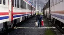 Seorang pria berjalan di antara kereta menggunakan tempat berlindung, di kota Iskenderun, Turki selatan, Selasa (14/2/2023). Ribuan orang kehilangan tempat tinggal akibat gempa dahsyat yang melanda Turki dan Suriah sepekan lalu memadati tenda-tenda yang penuh sesak atau mengantre di jalan-jalan untuk menikmati makanan hangat saat pencarian korban selamat yang putus asa memasuki jam-jam terakhir. (AP Photo/Hussein Malla)