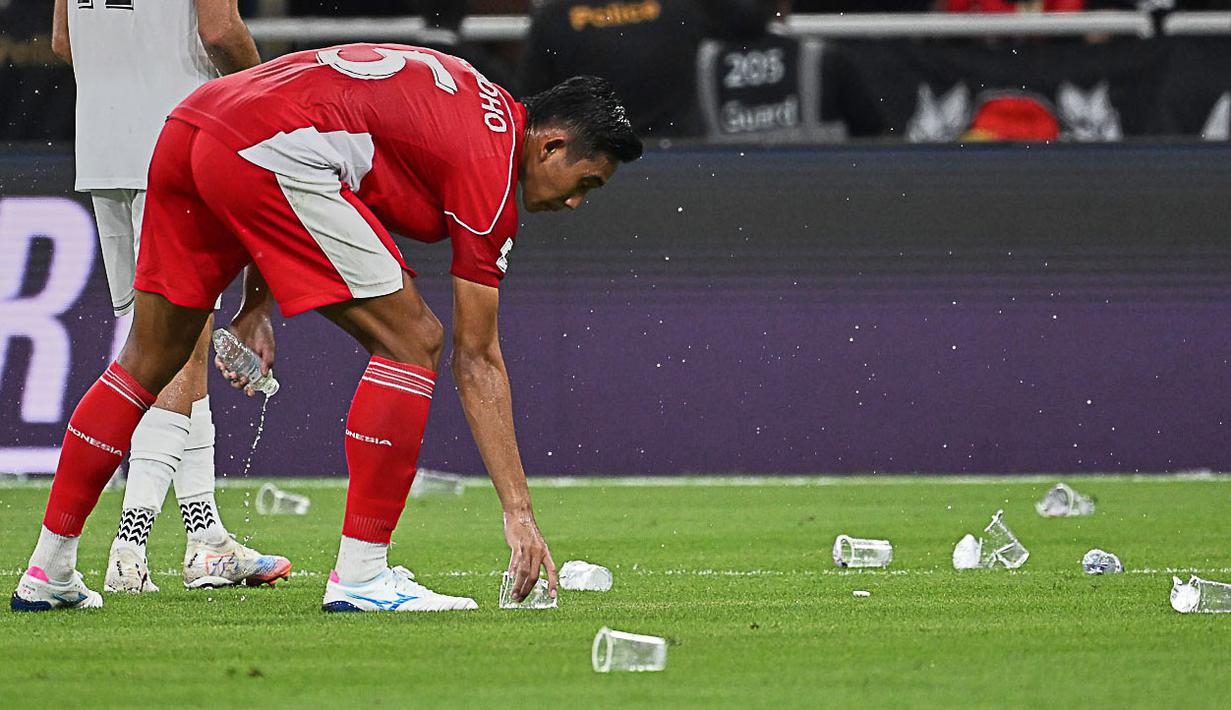 Hal tersebut sempat menunda pertandingan karena gelas dan botol plastik tersebut masuk ke dalam lapangan pertandingan. (AP Photo/Ali Issa)