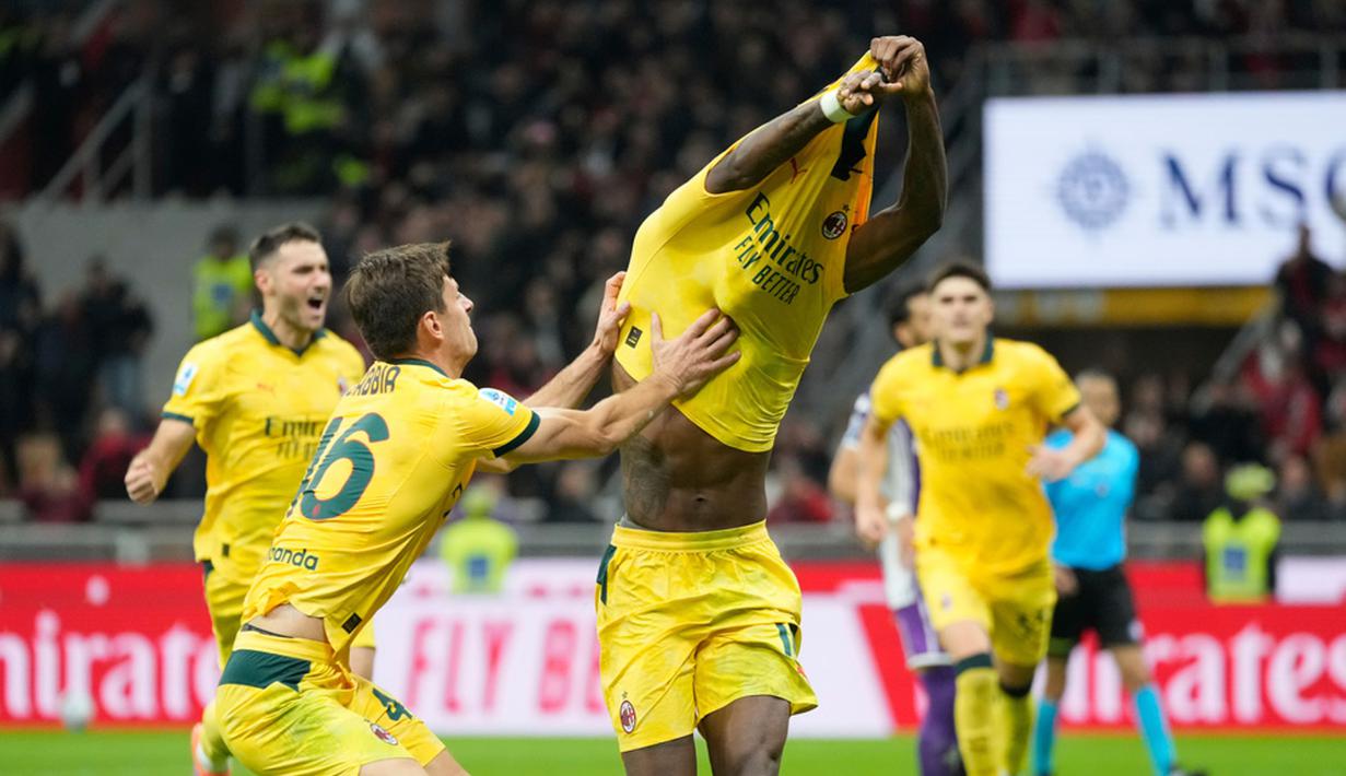 Pemain AC Milan, Matteo Gabbia, berusaha mencegah Rafael Leao melakukan selebrasi buka baju setelah mencetak gol ke gawang Fiorentina pada laga Liga Italia di Stadion San Siro. (AP Photo/Luca Bruno)