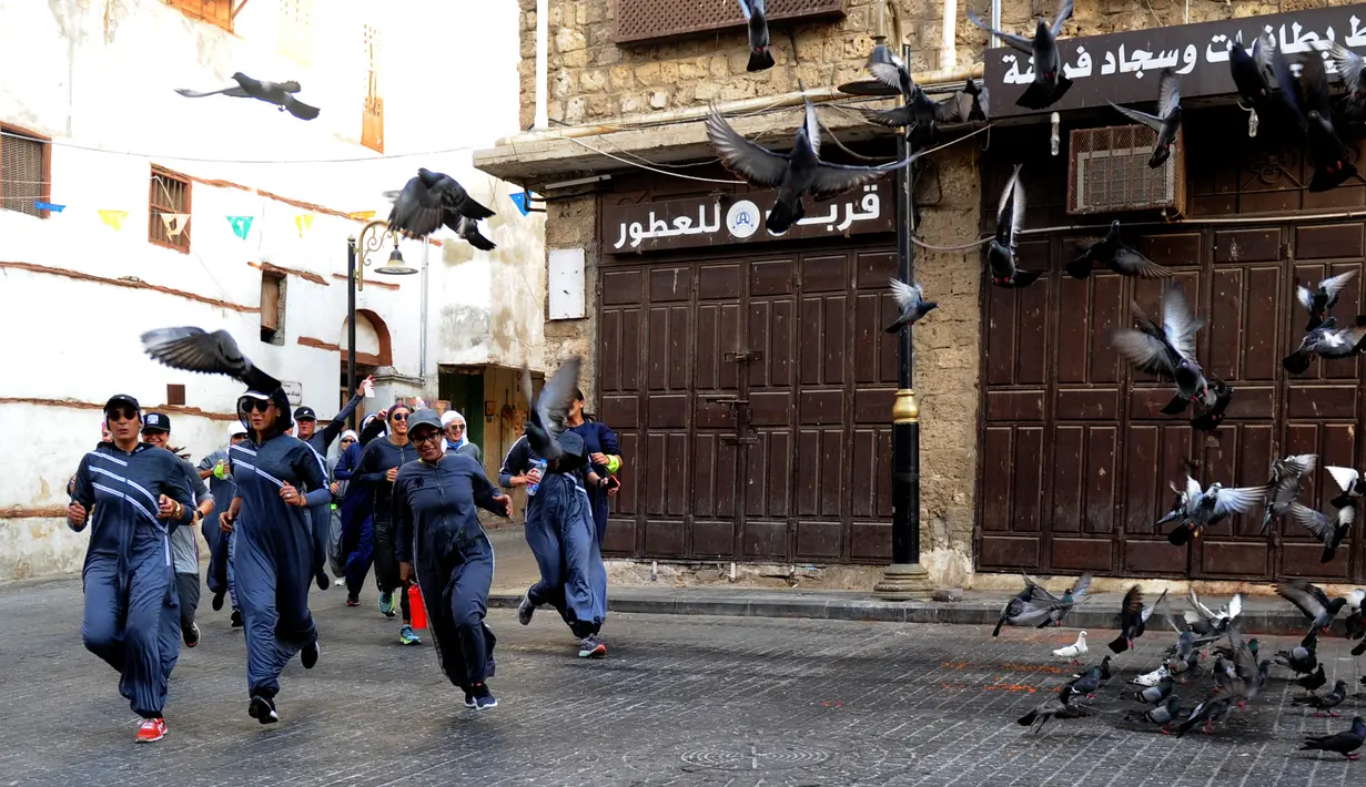 Perempuan Arab Saudi jogging dalam memperingati Women's Day atau Hari Perempuan Internasional di jalanan Distrik Al-Balad, Jeddah, Kamis (8/3). Kebijakan Putra Mahkota Mohammed bin Salman membuat banyak kebebasan bagi perempuan. (Amer HILABI/AFP)
