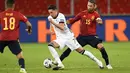 Gelandang Jerman Julian Draxler membawa bola dari kawalan bek Spanyol Sergio Ramos pada pertandingan UEFA Nations League di Stuttgart, Jerman (3/9/2020). Jerman bermain imbang 1-1 atas Spanyol. (AFP Photo/Thomas Kienzle)