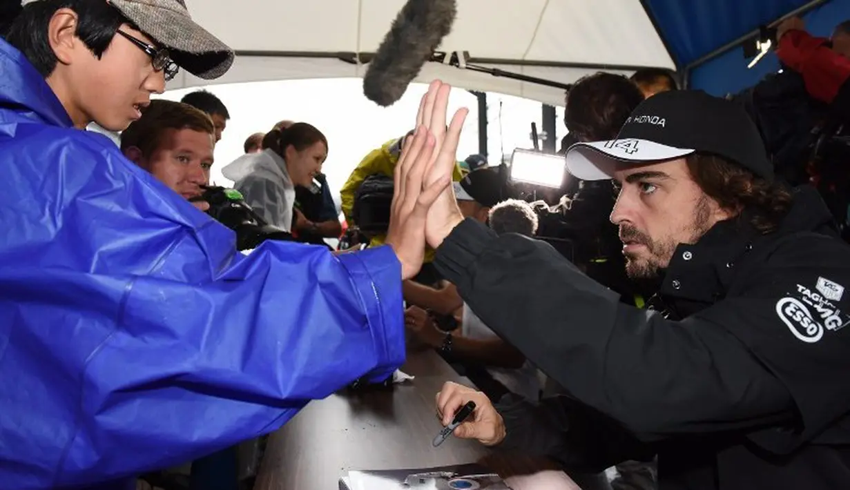 Pebalap McLaren, Fernando Alonso, memberikan salam kepada penggemarnya saat sesi jumpa fan F1 GP Jepang di Sirkuit Suzuka, Jepang, Kamis (24/9/2015). (AFP Photo/Toru Yamanaka)