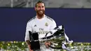 Bek Real Madrid, Sergio Ramos, mengangkat trofi juara La Liga usai mengalahkan Villrreal pada laga lanjutan pekan ke-37 di Estadio Alfredo Di Stefano, Jumat (17/7/2020) dini hari WIB. Real Madrid menang 2-1 atas Villarreal. (AFP/Gabriel Bouys)