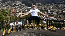 Bintang Real Madrid, Cristiano Ronaldo, menunjukan trofi pribadi di kampung halamannya di Madeira, Portugal, Senin (1/1/2018). Pemain bernomor punggung tujuh itu memamerkan 15 trofi individual yang ia raih sebagai pemain terbaik. (AFP/CR7 Media)