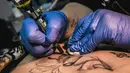 Seniman tato, Yevgeniya Zakhar saat membuat tato pada seorang korban KDRT untuk menutupi lukanya, di Ufa, Rusia (6/12/2016). (AP Photo/Vadim Braydov)