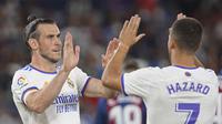 Pemain Real Madrid Gareth Bale (kiri) merayakan dengan Eden Hazard setelah mencetak gol ke gawang Levante pada pertandingan La Liga Spanyol di Stadion Ciutat de Valencia, Valencia, Spanyol, Minggu (22/8/2021). Pertandingan berakhir dengan skor 3-3. (AP Photo/Alberto Saiz)
