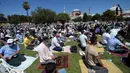 Umat muslim berdoa saat salat Jumat di distrik bersejarah Sultanahmet, dekat Hagia Sophia, Istanbul, Turki, Jumat (24/7/2020). Umat muslim melaksanakan salat Jumat pertama di Hagia Sophia dalam 86 tahun terakhir. (AP Photo/Yasin Akgul)