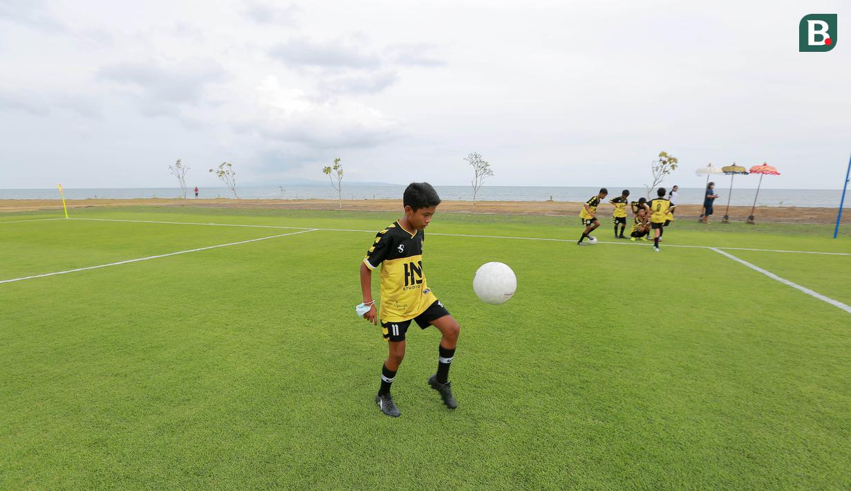 Seorang pesepak bola cilik melakukan juggling di Training Ground Bali United, Gianyar, Senin (28.03/2022). Mereka tampak senang menjajal lapangan latihan Bali United yang berada di pinggir pantai. (Bola.com/ M Iqbal Ichsan)
