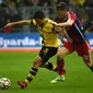 Sokratis (kiri) berebut bola dengan Bastian Schweinsteiger (PATRIK STOLLARZ / AFP)