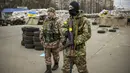 Seorang prajurit Ukraina memiliki tulisan "Mommy" pada tali senjatanya saat dia berjaga di sebuah pos pemeriksaan di jalan utama di Kyiv, Ukraina, 7 Maret 2022. (AP Photo/Vadim Ghirda)