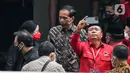 Presiden Joko Widodo atau Jokowi (tengah) berbincang dengan Ketua DPR RI yang juga menjabat sebagai Ketua DPP PDIP Puan Maharani usai hadir dalam pemembuka Rakernas II PDIP di Jakarta, Selasa (21/6/2022). Rakernas PDIP kali ini mengusung tema "Desa Kuat, Indonesia Maju dan Berdaulat".  (Liputan6.com/Faizal Fanani)