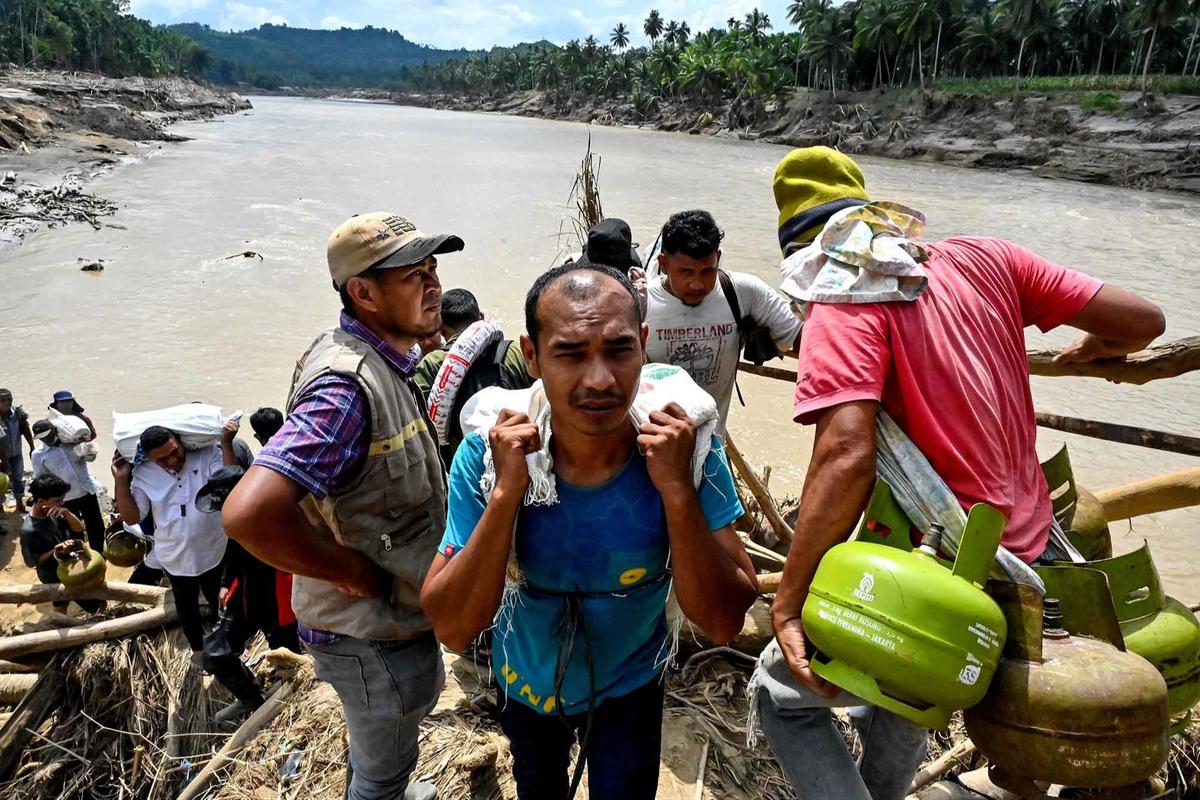 FOTO: Warga Memanjat Puing Kayu Demi Menyeberangi Sungai Peusangan