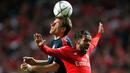 Penyerang Muenchen, Thomas Muller (kiri) berebut bola udara dengan gelandang Benfica, Mehdi Carcela Gonzalez di leg kedua Liga Champions di Stadion Da Luz, Lisboa, Portugal, Kamis (14/4). (Reuters/Rafael Marchante)