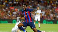Gelandang Barcelona, Franck Kessie (kanan), terjatuh usai ditekel oleh pemain Pumas Unam, Arturo Ortiz, dalam laga bertajuk Trofeo Joan Gamper, Minggu (7/8/2022) malam waktu setempat. (AP Photo/Joan Monfort)