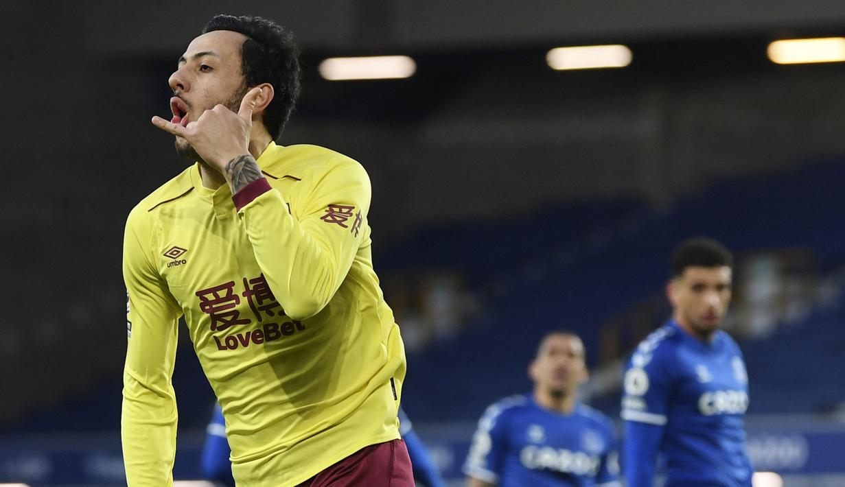 Pemain Burnley, Dwight McNeil, melakukan selebrasi usai mencetak gol ke gawang Everton pada laga Liga Inggris di Stadion Goodison Park, Sabtu (13/3/2021). Burnley menang dengan skor 2-1. (Gareth Copley/Pool via AP)