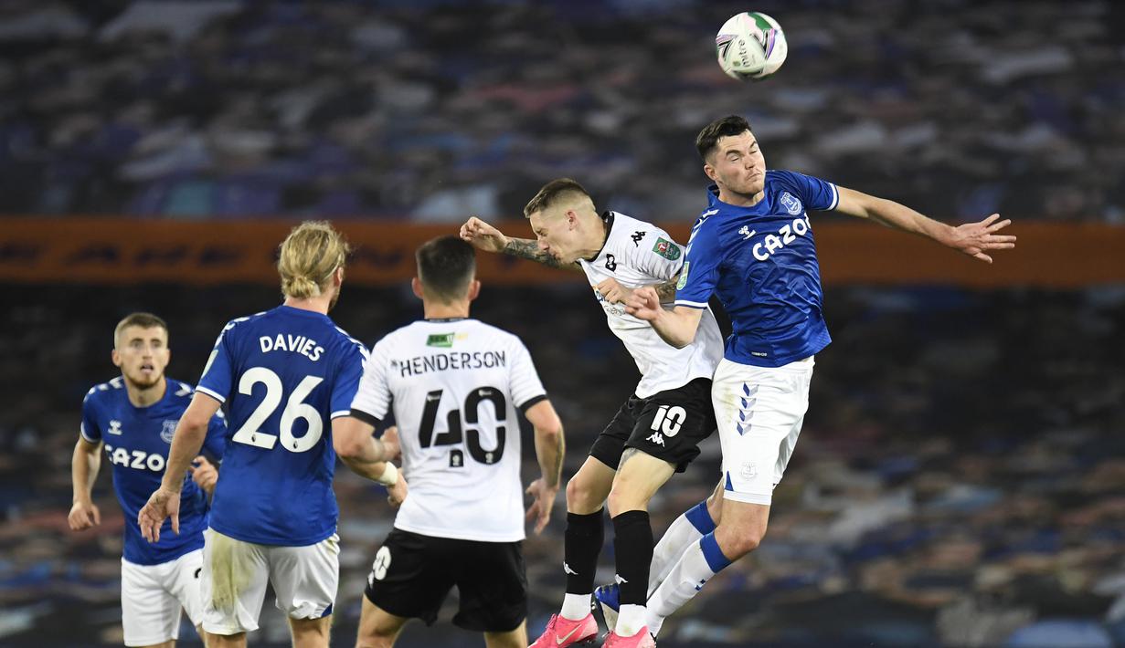 Bek Everton, Michael Keane, berebut bola atas dengan penyerang Salford City, Ashley Hunter, pada laga Piala Inggris di Stadion Goodison Park, Kamis (17/9/2020) dini hari WIB. Everton menang 3-0 atas Salford City. (AFP/Peter Powell/pool)