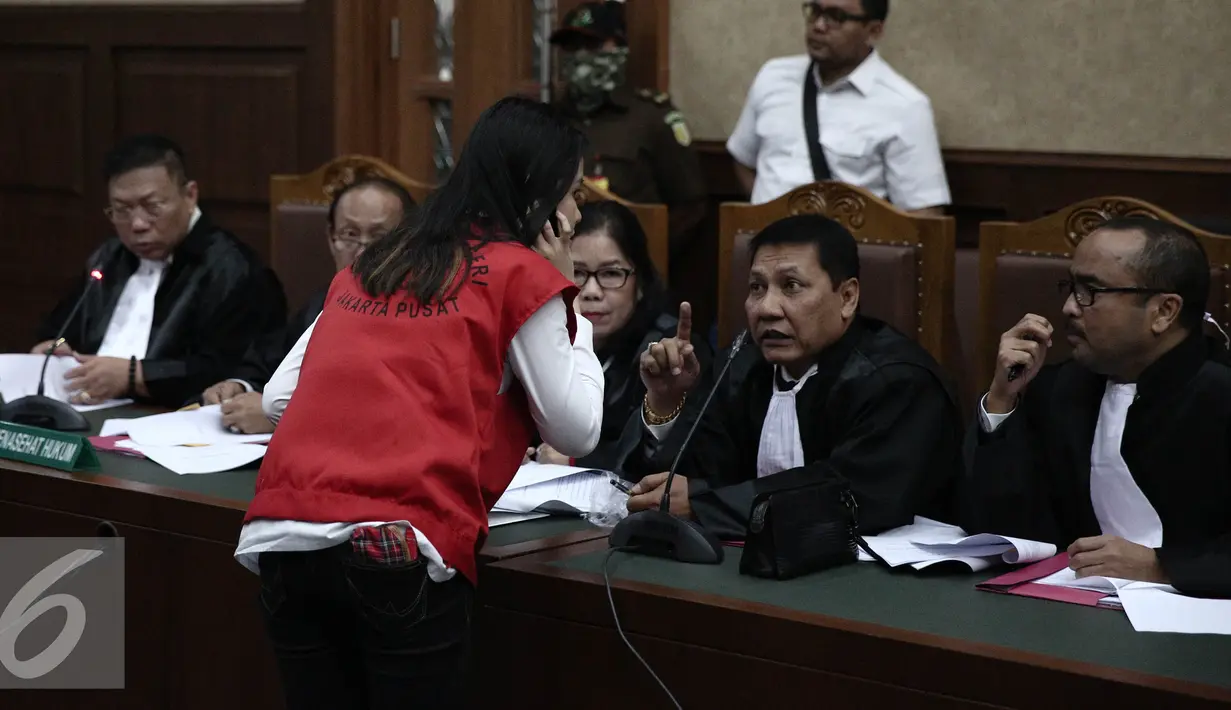 Jessica Kumala Wongso berdiskusi dengan kuasa hukumnya saat menjalani sidang perdana di PN Jakarta Pusat, Rabu (15/6). Dalam Sidang ini Jessica mengajukan eksepsi atau keberatan kepada majelis hakim. (Liputan6.com/Faizal Fanani)