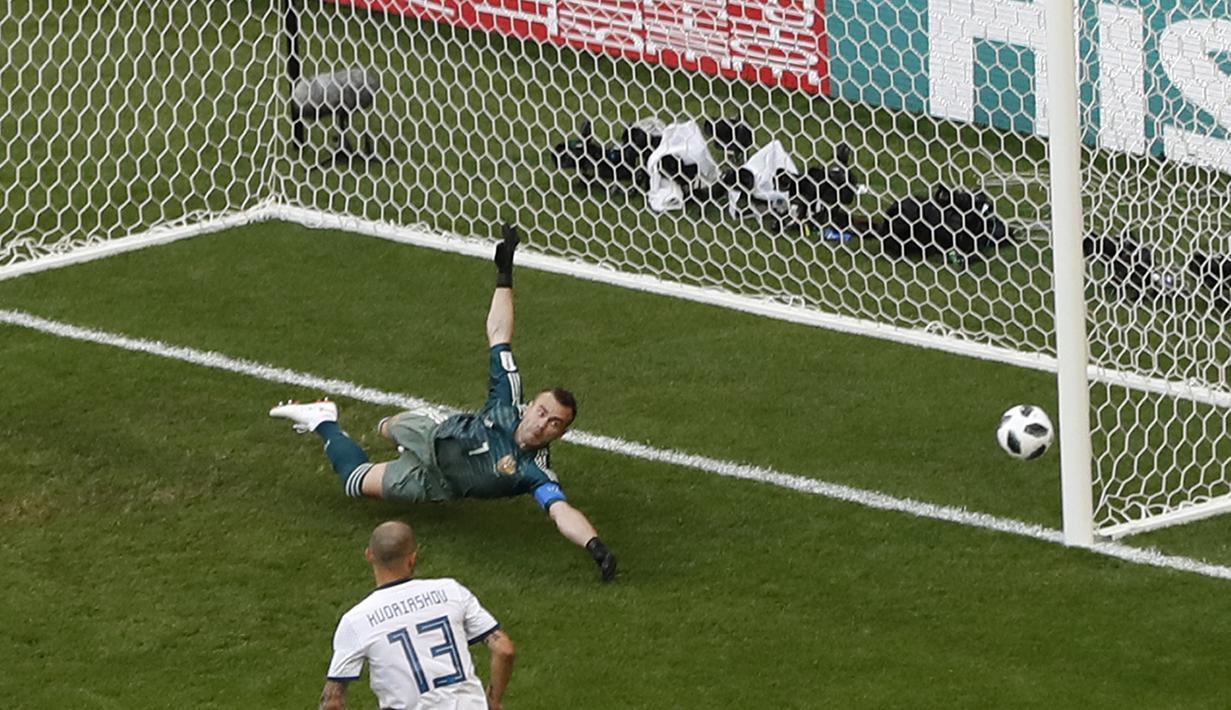 Kiper Rusia, Igor Akinfeev gagal menghalau bola sepakan Luis Suarez pada laga grup A Piala Dunia 2018 di Samara Arena, Samara, Rusia, (25/6/2018). Uruguay menang 3-0. (AP/Efrem Lukatsky)