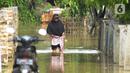 Warga melintasi banjir di Desa Karangligar dan Dusun Pengasinan kecamatan Teluk Jambe Barat, Kabupaten Karawang, Selasa (6/12/2022).  Banjir yang terjadi setelah hujan deras yang mengguyur sejak Minggu (4/12/2022) mulai berangsur surut. (merdeka.com/Imam Buhori)
