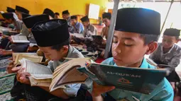 Tadarus Al-Qur'an massal merupakan kegiatan membaca Al-Qur'an secara berjamaah. Kegiatan tadarus Al Quran massal dilakukan usai salat Dzuhur berjamaah. (merdeka.com/Arie Basuki)