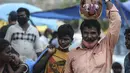 Seorang pria membawa labu yang dilukis dengan wajah setan selama festival Hindu 'Durga Puja' di pasar grosir di Chennai (13/10/2021). Durga Puja juga disebut Durgotsab adalah festival tahunan di Asia Selatan untuk memuja dewi Durga dari agama Hindu. (AFP/Arun Sankar)