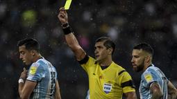 Wasit,Roddy Zambrano memberikan kartu kuning untuk  Ramiro Funes Mori (kiri) saat melanggar pemain Venezuela pada kualifikasi Piala Dunia 2018 zona Conmebol di Merida, Venezuela, (7/9/2016) WIB. (AFP/Juan  Barreto)