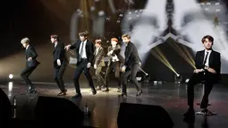 Penampilan boyband K-pop, BTS dalam konser negara persahabatan antara Korea Selatan dan Prancis yang digelar di Paris, Minggu (14/10). Pada penampilan tersebut personel BTS, Jungkook, masih duduk di kursi karena cedera kaki. (YOAN VALAT/POOL/AFP)