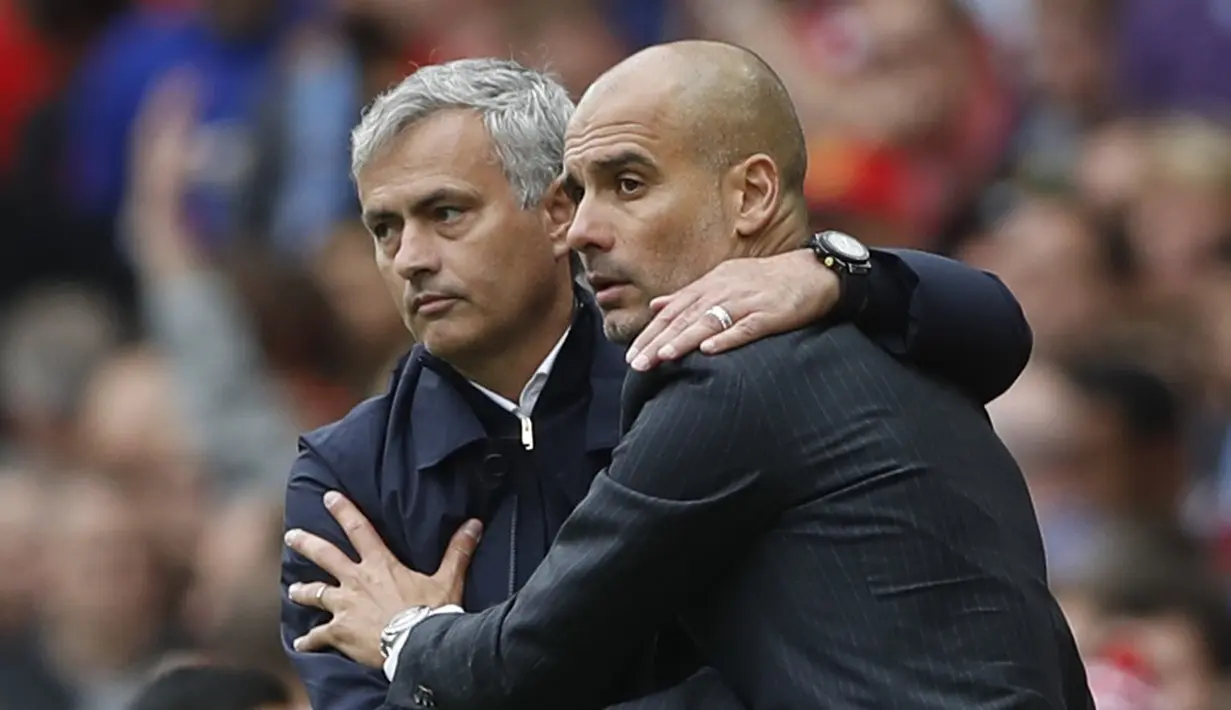Pelatih Manchester United, Jose Mourinho (kiri) dan pelatih  Manchester City, Pep Guardiola (R) berpelukan sebelum laga Derby Manchseter dimulai pada laga Premier League di Old Trafford, Manchester,  (10/9/2016). (Reuters/Carl Recine)