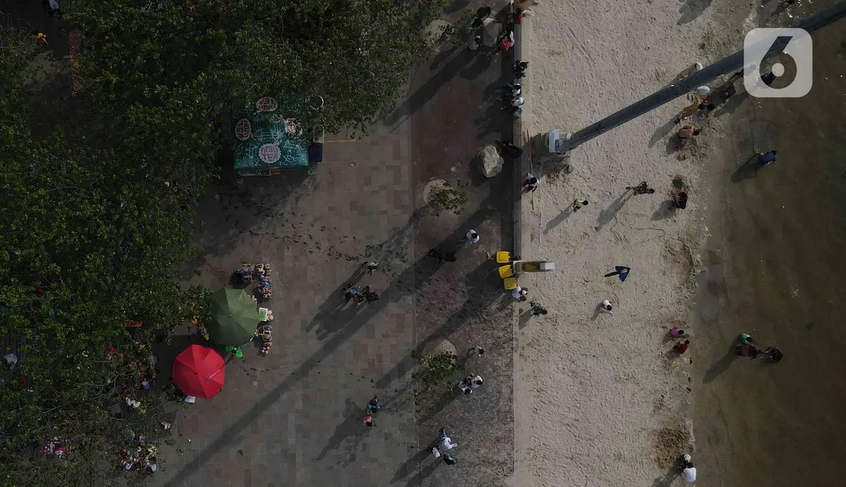 Pemandangan udara warga berlibur di Pantai Ancol, Pademangan, Jakarta Utara, Rabu (1/6/2022). Libur Nasional Hari Lahir Pancasila, dimanfaatkan warga mengajak sanak saudara tamasya di Pantai Ancol. (Liputan6.com/Herman Zakharia)