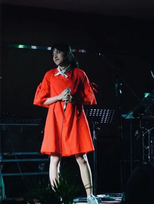 Memadukan dress berwarna merah terang di penampilannya saat berada di atas panggung semakin manis dengan scarf berwarna putih yang diikatkan di lehernya. Kekinian banget kan? (Instagram/Ifyalyssa)
