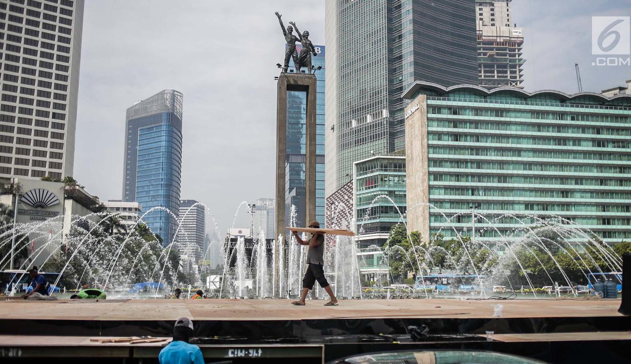 Pekerja menyelesaikan pembuatan panggung HUT ke-492 DKI di area Bundaran HI, Jakarta, Kamis (20/6/2019). Sejumlah artis Ibu Kota akan menghibur dalam peringatan HUT ke-492 DKI Jakarta. (Liputan6.com/Faizal Fanani)