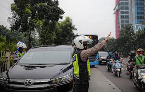 Anggota polisi melakukan penindakan kepada sebuah kendaraan saat ganjil genap di kawasan Jalan D.I Panjaitan, Jakarta, Senin (6/6/2022). Perluasan ganjil genap juga sesuai dengan Pergub DKI Jakarta Nomor 88 Tahun 2019. (Liputan6.com/Faizal Fanani)