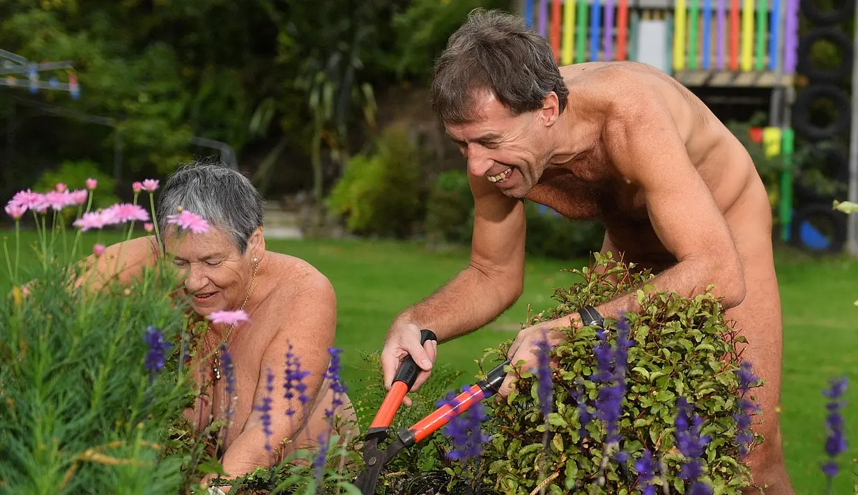 June Campbell-Teng (kiri), Brent Anderson memangkas tanaman saat berpartisipasi dalam World Naked Gardening Day di Wellington Naturist Club di Upper Hutt, Wellington , Selandia Baru (5/5). (AFP Photo/Marty Melville)