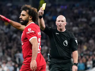 Wasit Simon Hooper memberikan kartu kuning kepada pemain Liverpool Mohamed Salah saat pertandingan sepak bola Liga Inggris antara Tottenham Hotspur dan Liverpool di Tottenham Hotspur Stadium, London, Inggris, Sabtu (30/9/2023). Tottenham Hotspur mengalahkan Liverpool dengan skor 2-1. (AP Photo/Alberto Pezzali)