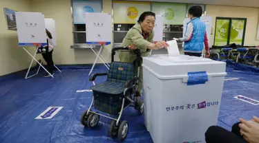 Seorang wanita memasukkan surat suara di sebuah TPS di Seoul, Korea Selatan (Korsel), Selasa (9/5). Warga Korsel menggunakan hak suaranya untuk memilih presiden baru setelah pemakzulan Park Geun-hye yang dijerat skandal korupsi. (AP Photo/Ahn Young-joon)